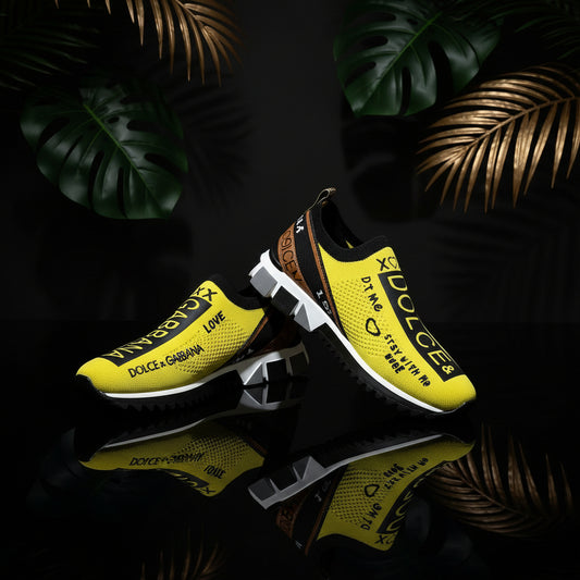 A pair of flat white sneakers with black text and design elements, worn by a person with visible jeans.