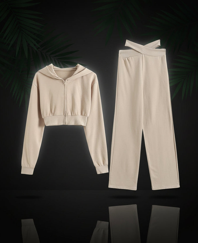 A set of beige color clothing which includes a hooded long sleeve crop sweatshirt and matching trousers.
