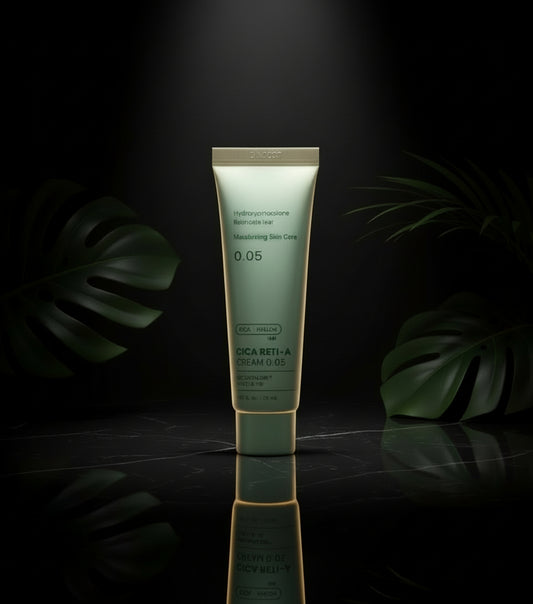 Person holding a tube of Cica Reti-A cream in a bathroom setting.