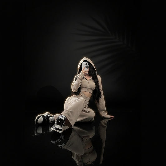 A set of beige color clothing which includes a hooded long sleeve crop sweatshirt and matching trousers.