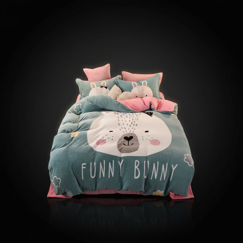 A four-piece bed sheet set with a cartoon theme, featuring a blue color with white polka dots and text, displayed on a bed with pillows and a quilt.