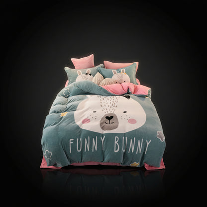 A four-piece bed sheet set with a cartoon theme, featuring a blue color with white polka dots and text, displayed on a bed with pillows and a quilt.