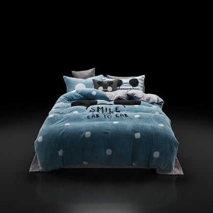 A four-piece bed sheet set with a cartoon theme, featuring a blue color with white polka dots and text, displayed on a bed with pillows and a quilt.