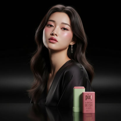 A woman with a pink blush on her cheeks, holding a pixi beauty blush stick with the shade 'Ruby' displayed alongside.