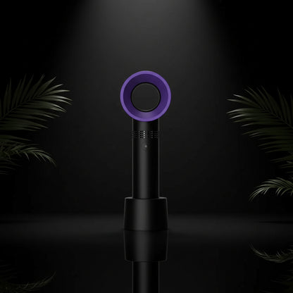 A handheld rechargeable eyelash blower with a pink circular mouthpiece and a teal blue body, being held in a person's hand.