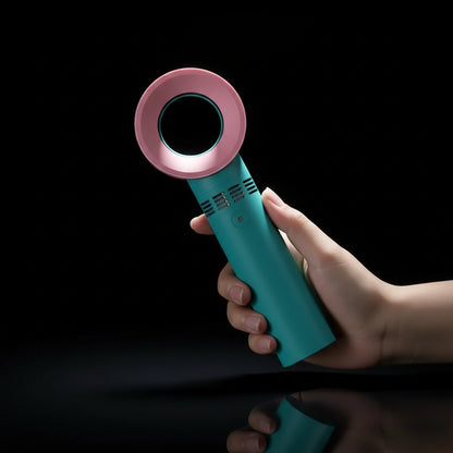 A handheld rechargeable eyelash blower with a pink circular mouthpiece and a teal blue body, being held in a person's hand.
