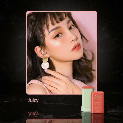 A woman with a pink blush on her cheeks, holding a pixi beauty blush stick with the shade 'Ruby' displayed alongside.