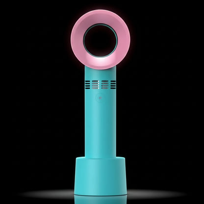 A handheld rechargeable eyelash blower with a pink circular mouthpiece and a teal blue body, being held in a person's hand.